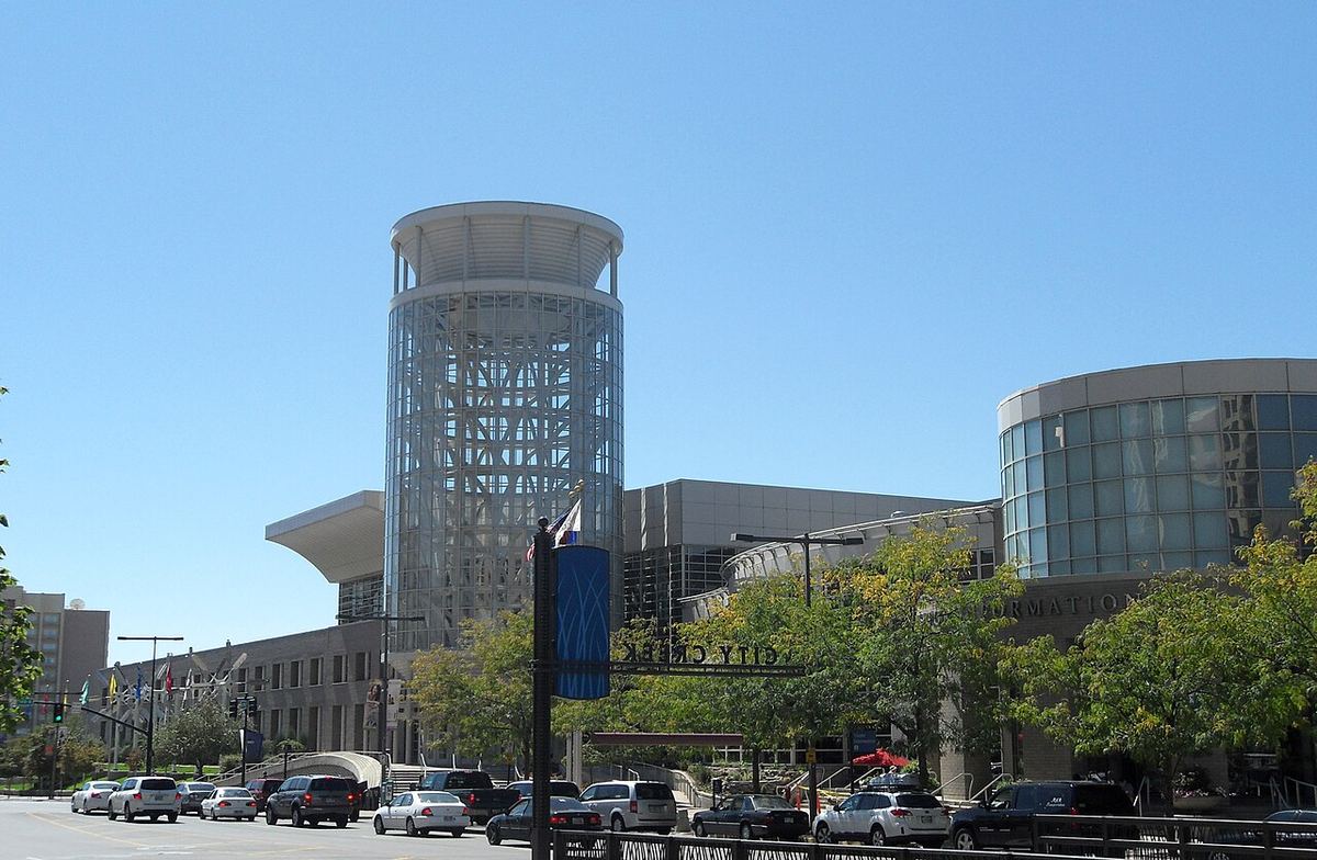 The Salt Palace convention center's glass tower and curved facade on a sunny day in downtown Salt Lake City